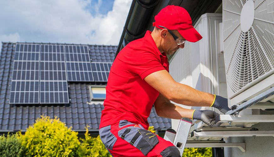 man performing maintenance on a heat pump