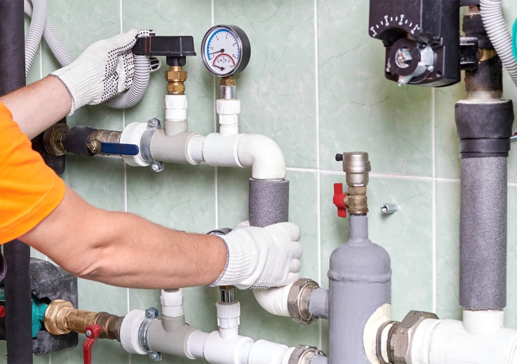 commercial plumber installing pipe