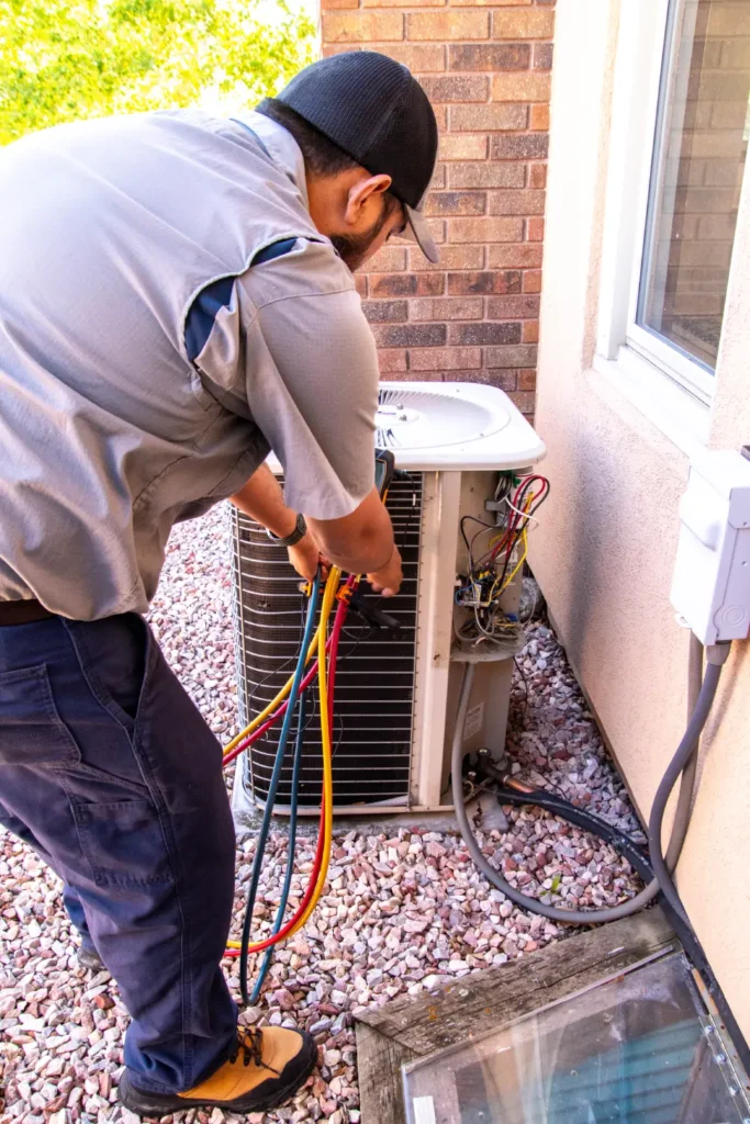 Technician repairing outdoor air conditioning unit