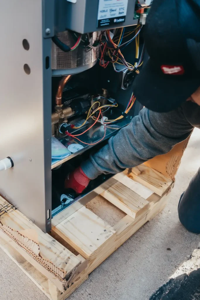 Technician servicing a home heating furnace system repair