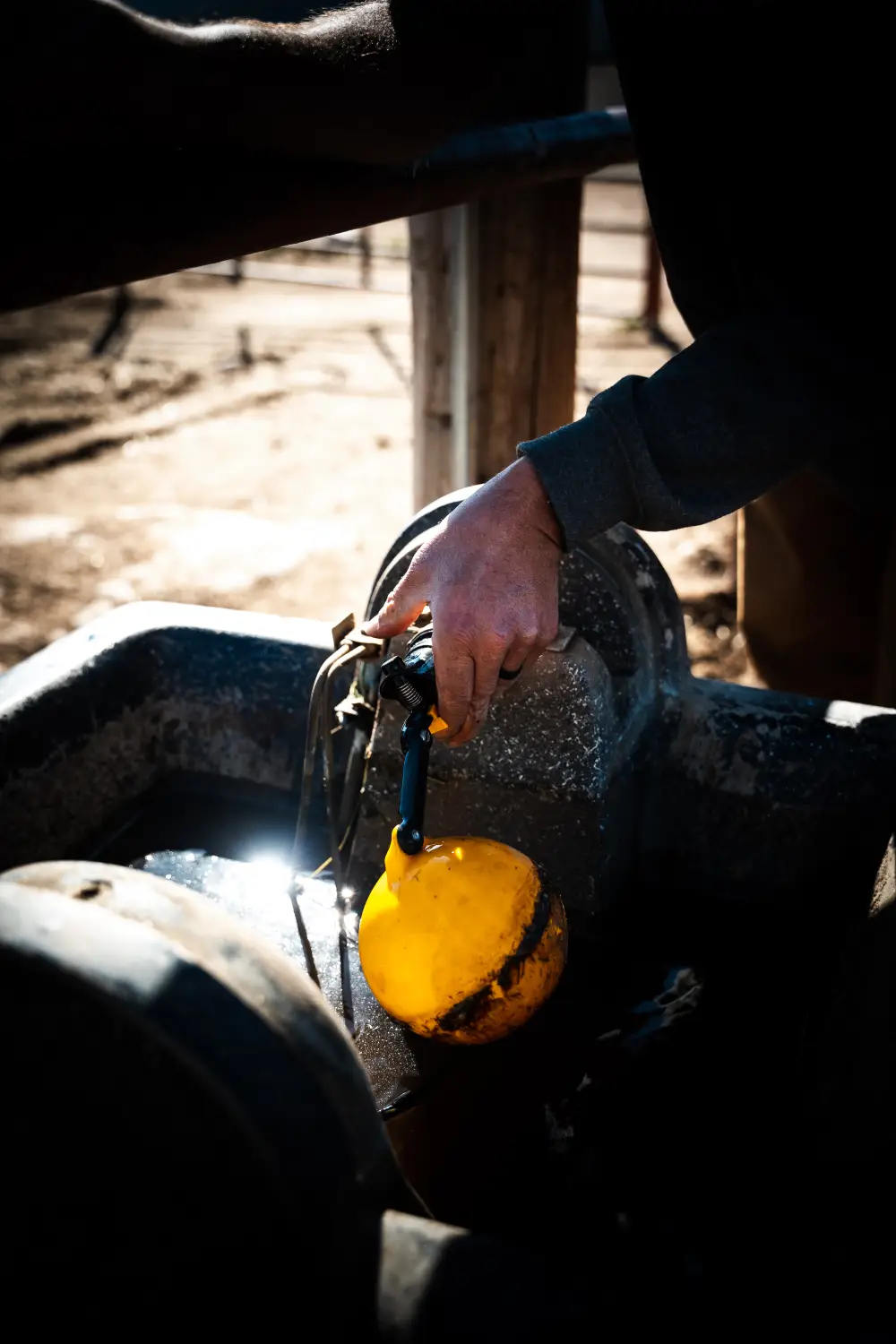 Person cleaning yellow tool in a vintage water basin setup