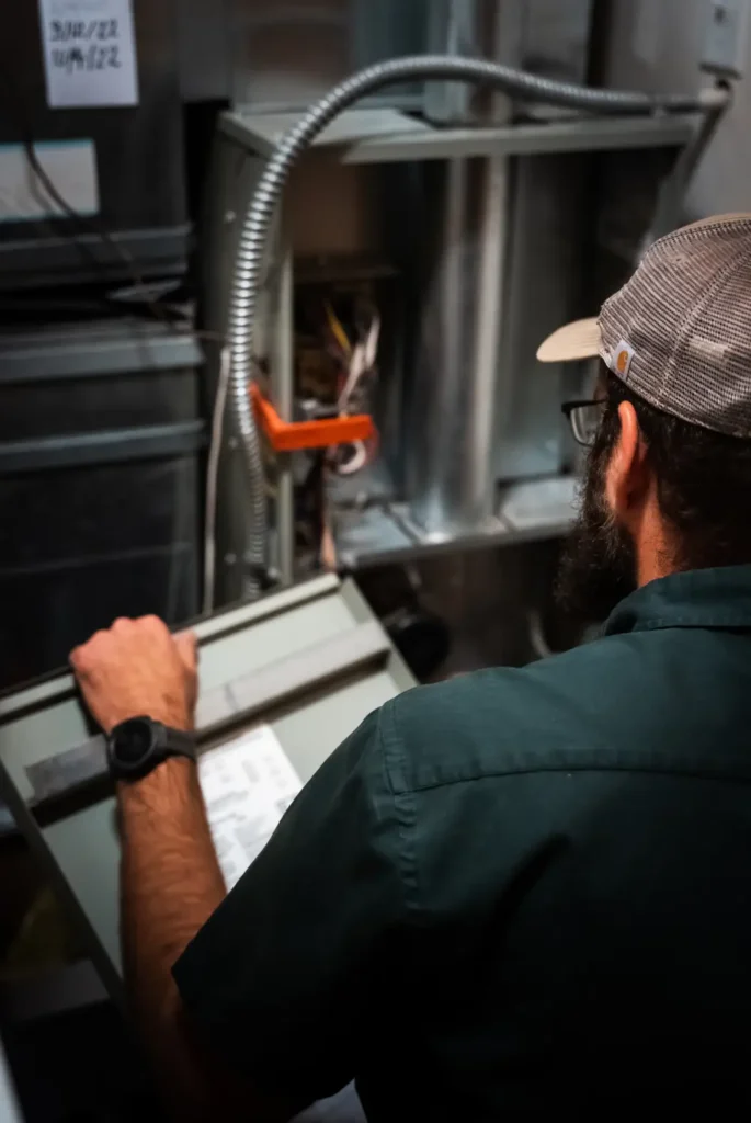 Technician inspecting HVAC system for maintenance and repair