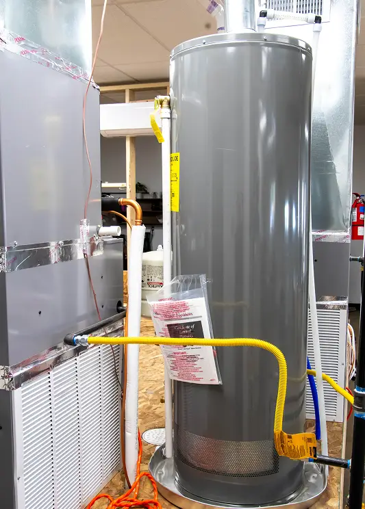 A newly installed water heater surrounded by HVAC equipment in a mechanical room.