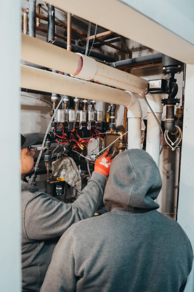 Technicians servicing plumbing and HVAC systems in a Colorado residential property.